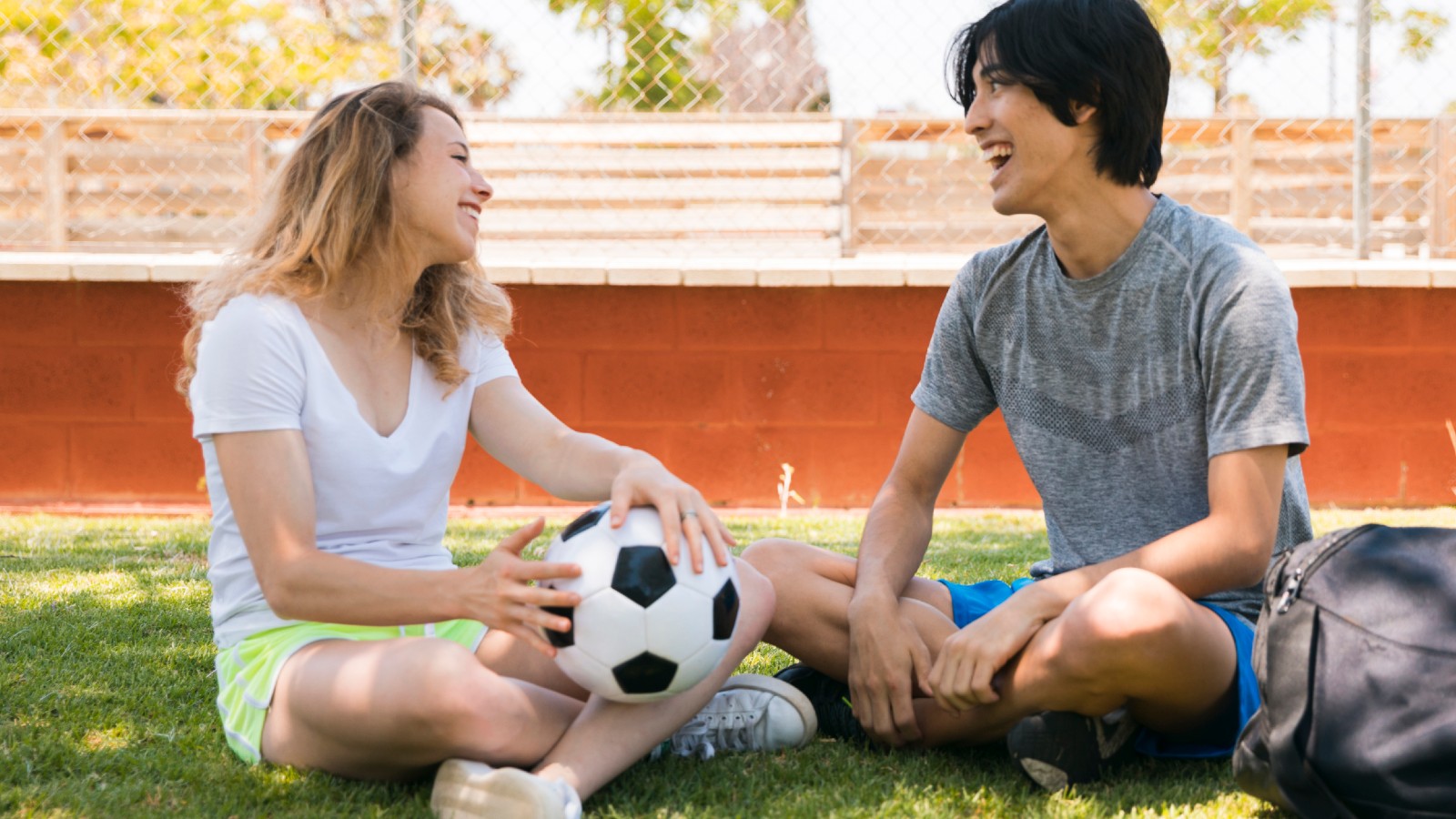 Teenage girl and boy having a conversation after playing sport