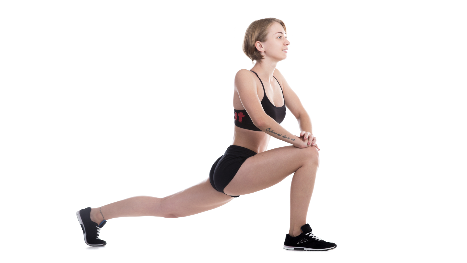 Woman in fitness attire demonstrating a stationary lunge