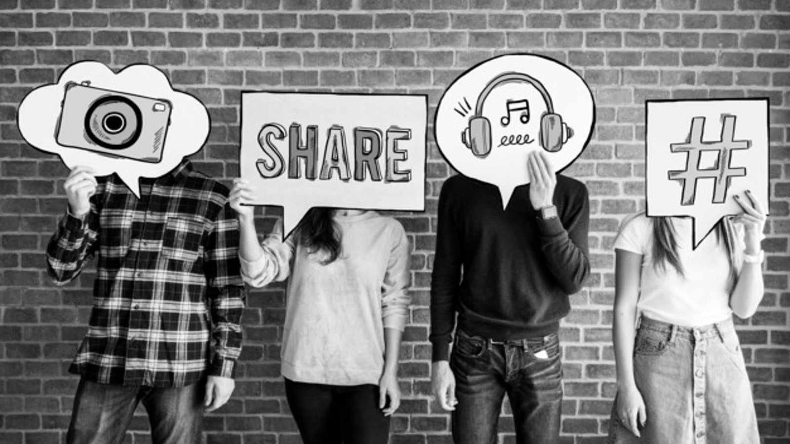 four young adults holding up thought bubble cards containing social media icons