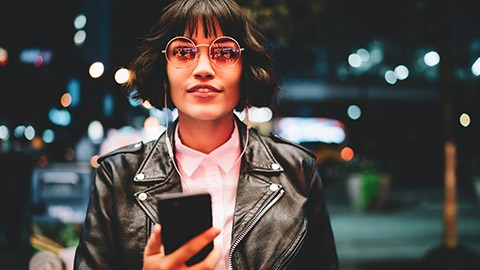 Female hipster with mobile phone in city setting