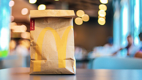 McDonalds food bag sitting on a table in the restaurant