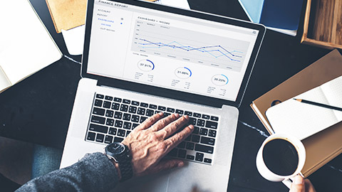 Top down view of businessman sitting at a desk preparing a financial report