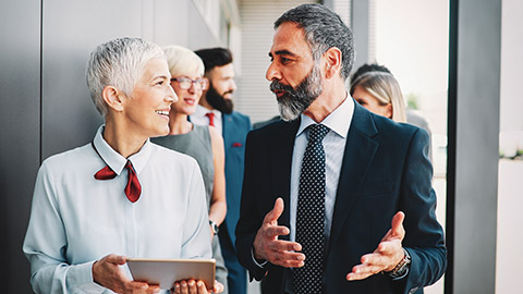 Male and female colleagues talking about business outside of office building