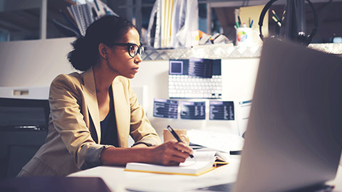 African american female writing on notebook at her desk