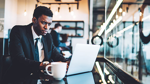 An accountant sitting in a modern office space working on their laptop