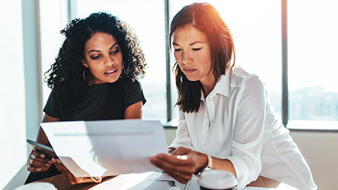 2 accountants looking over a financial document before signing it off