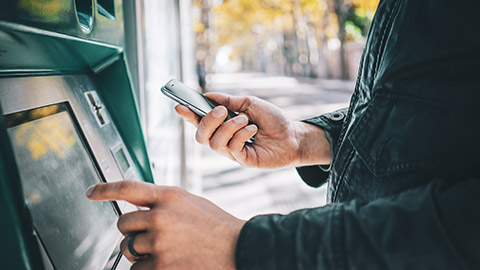 Close view of a man entering data into an ATM