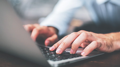 Close view of man typing on laptop