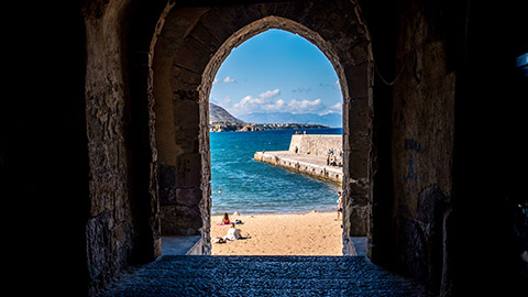 View of beach area through stone archway